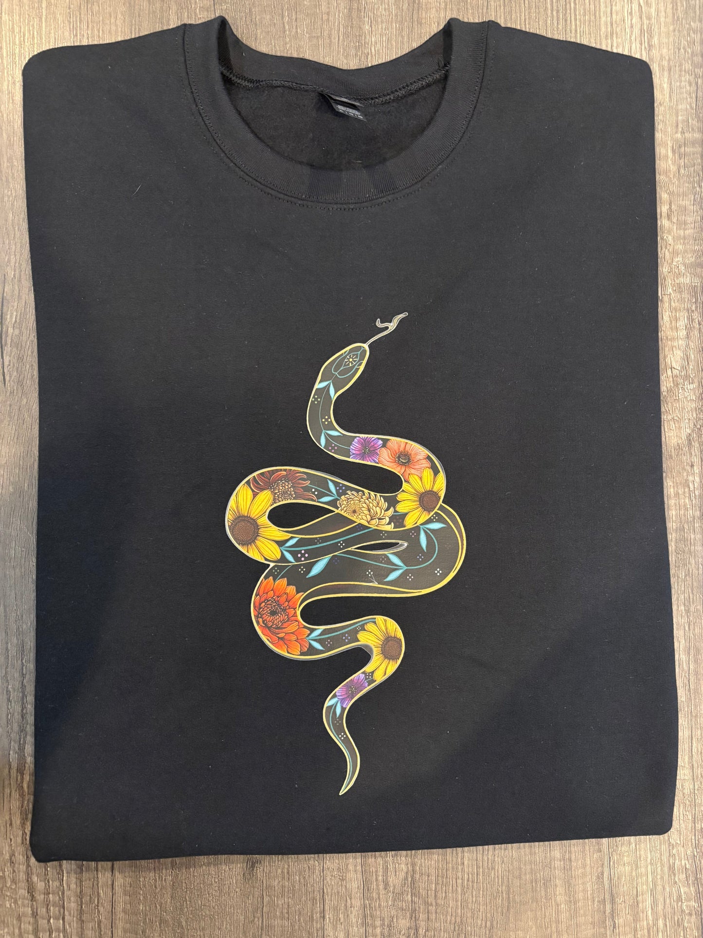 A black t-shirt with a printed snake design on the front.